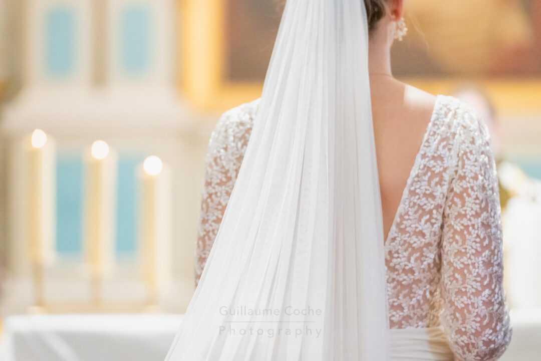 Reportage photo de mariage robe en dentelle et voile de la mariée et cierges à l'église de Crac'h - Guillaume Coche Photography